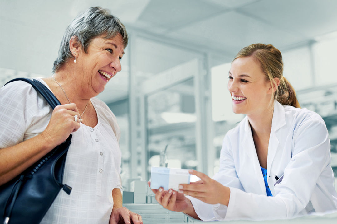pharmacist handing box to patient